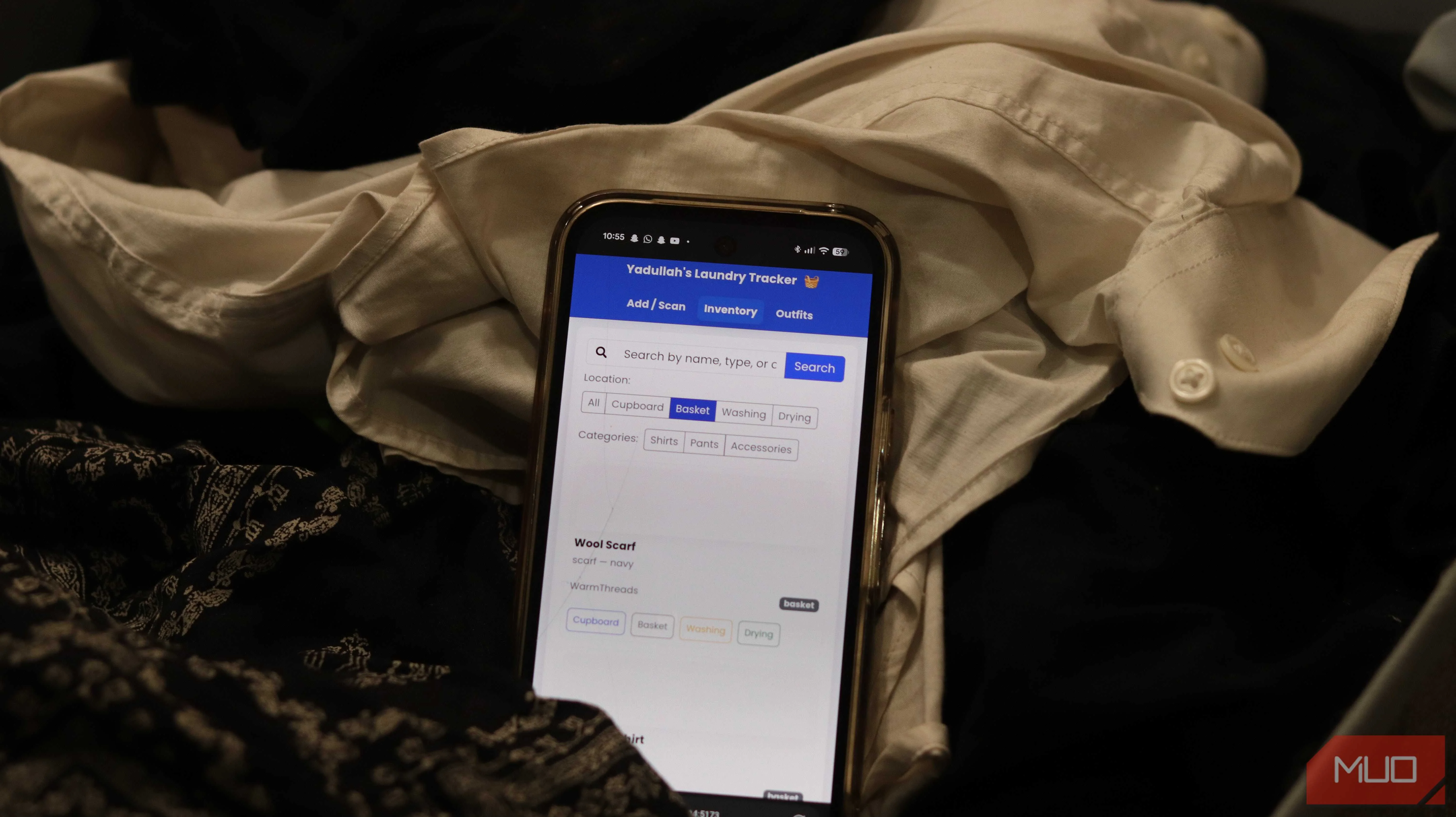 Laundry tracking app on a phone inside a laundry basket.